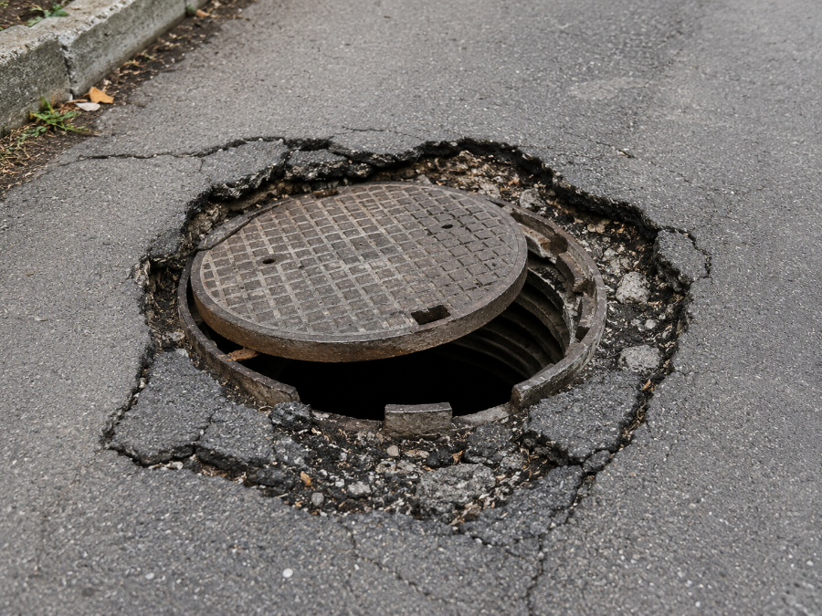 Çökmüş yol logarı: kapak yerinden çıkmış, çevresindeki asfalt kırılmış